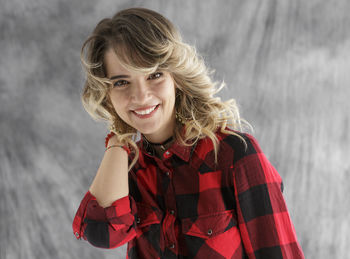 Young woman standing against backdrop