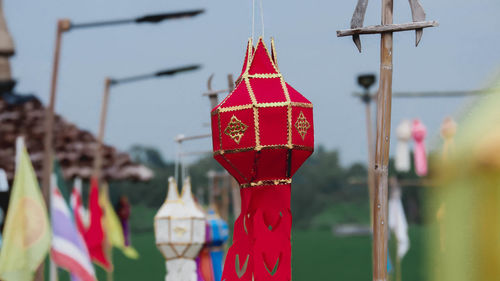 Close-up of red bell hanging against blurred background