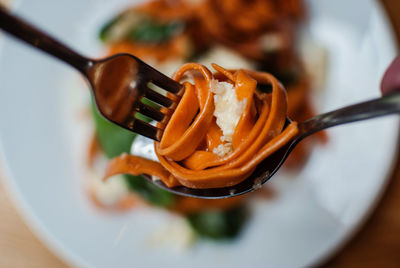 Close-up of hands holding food in fork