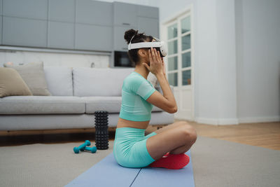 Side view of young woman exercising in gym