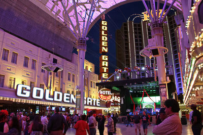 People on illuminated street at night