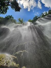 Scenic view of waterfall against sky