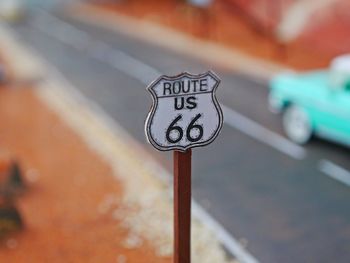 Close-up of road sign against sky