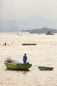 Rear view of men on boat in sea