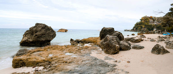 Rocks on beach against sky