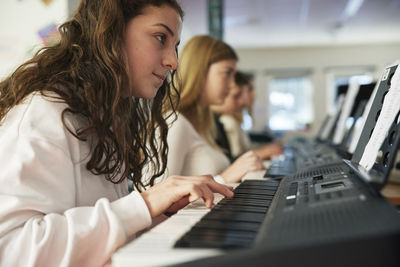 Teenagers attending keyboard lesson