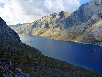 Scenic view of lake by mountains against sky