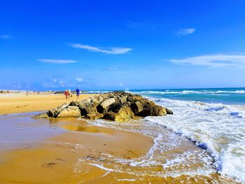 Scenic view of beach against blue sky