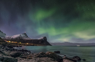 Northern lights on sky. scenic view of sea against sky at night