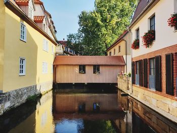 Canal amidst buildings against sky