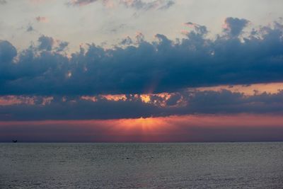 Scenic view of sea against dramatic sky during sunset