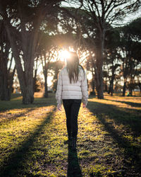 Rear view of woman walking in sunlight