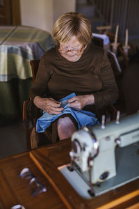 Senior woman working on garment at home