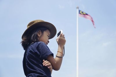 Low angle view of woman standing against sky