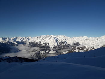Scenic view of snowcapped mountains against clear blue sky