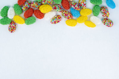 High angle view of multi colored candies against white background