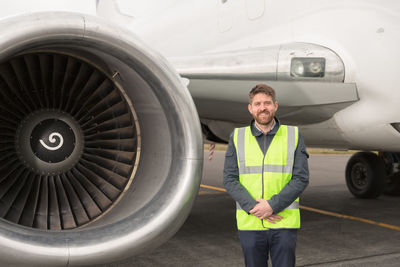 Positive engineer standing near plane