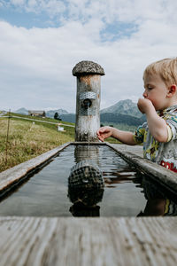 Boy on shore against sky