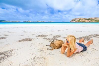 Woman with kangaroo relaxing at beach