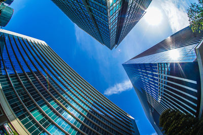 Low angle view of modern buildings against blue sky