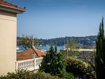 Houses by sea against clear sky