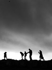 Silhouette people standing against sky