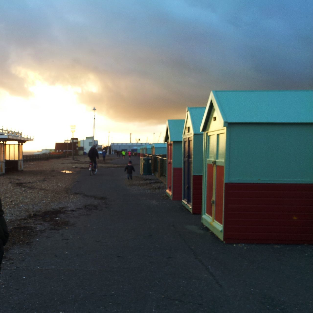 sky, built structure, architecture, building exterior, cloud - sky, sea, the way forward, sunset, beach, cloud, incidental people, cloudy, sand, outdoors, street light, horizon over water, water, nature, in a row