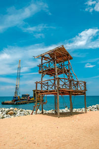 Lifeguard hut on beach against sky