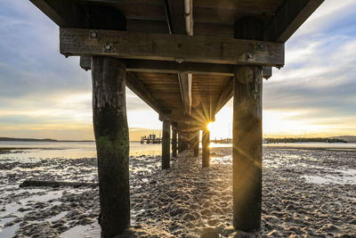 Pier over sea against sky during sunset