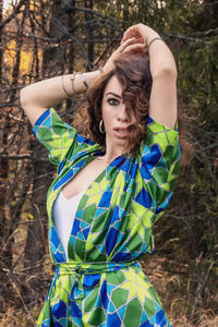 Young woman standing against trees