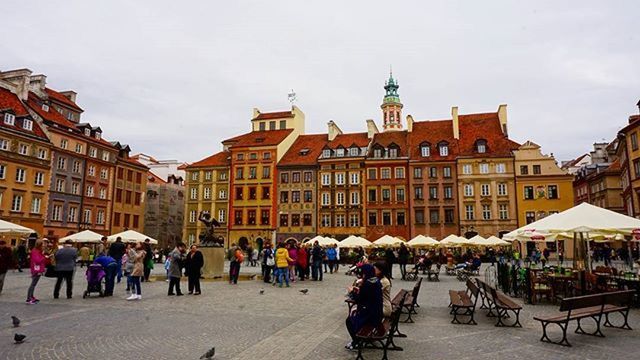 building exterior, architecture, built structure, large group of people, city, men, person, street, city life, sky, travel destinations, facade, tourism, building, travel, town square, walking, old town, day