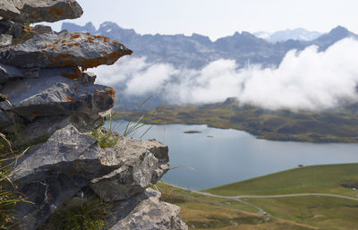 Close-up of rock by lake against mountains