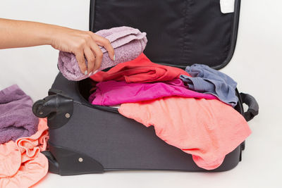 Cropped image of woman packing luggage