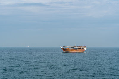 Sailboat sailing on sea against sky