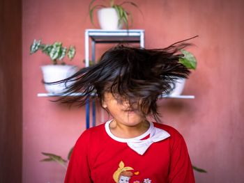 Girl standing against wall at home