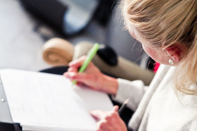 Young woman writing on paper at home
