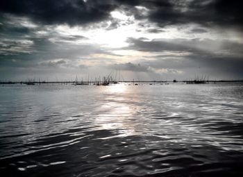 Scenic view of sea against cloudy sky at sunset