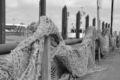 Close-up of fishing net on wooden post at harbor