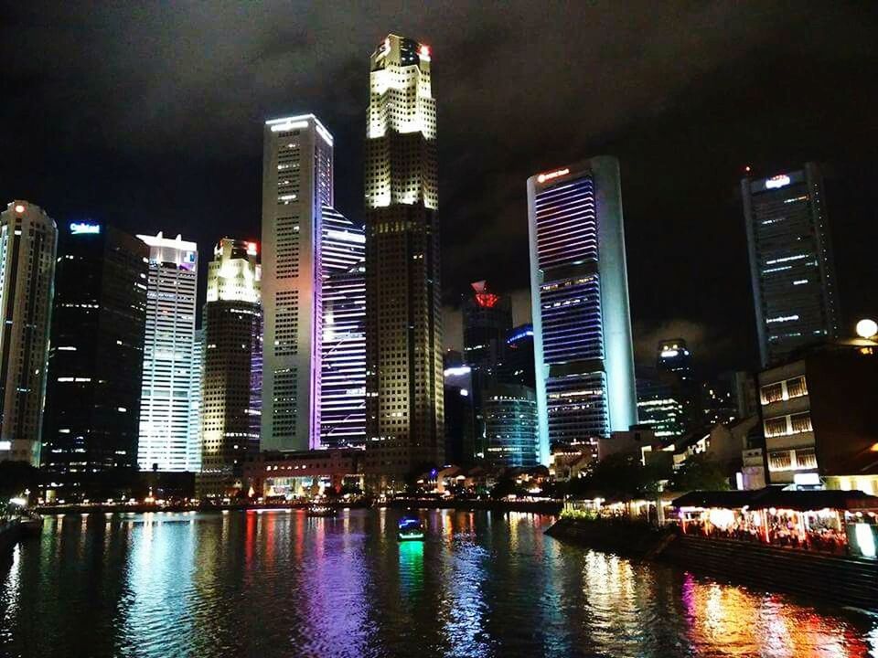 LOW ANGLE VIEW OF ILLUMINATED CITY AT WATERFRONT