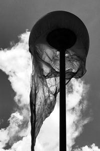 Low angle view of statue holding flag against sky