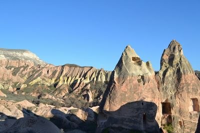 Rock formations on landscape against blue sky