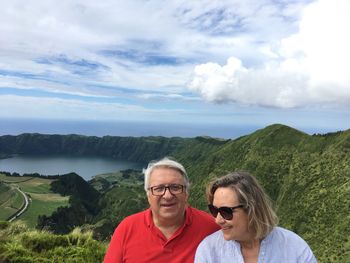 Smiling couple on mountain against sky