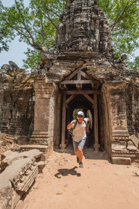 Full length of woman running at entrance of old historic temple