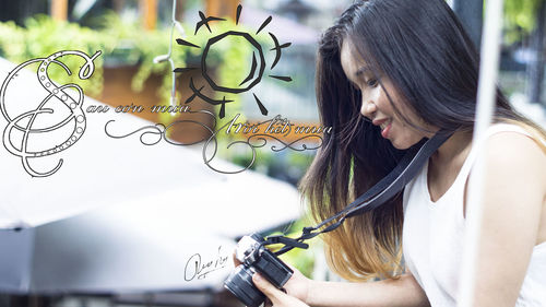 Side view portrait of young woman holding plant