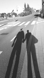Shadow of people on road in city