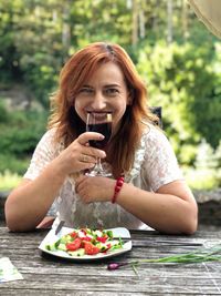 Portrait of smiling woman eating food outdoors