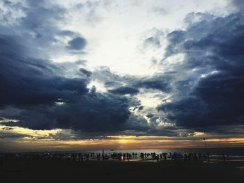 Scenic view of beach against dramatic sky