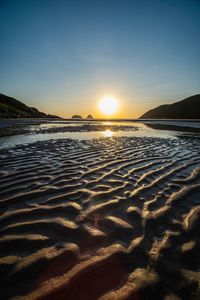 Scenic view of beach against sky during sunset