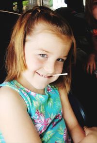 Portrait of smiling girl eating candy