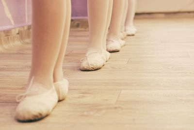 Low section of people standing on hardwood floor